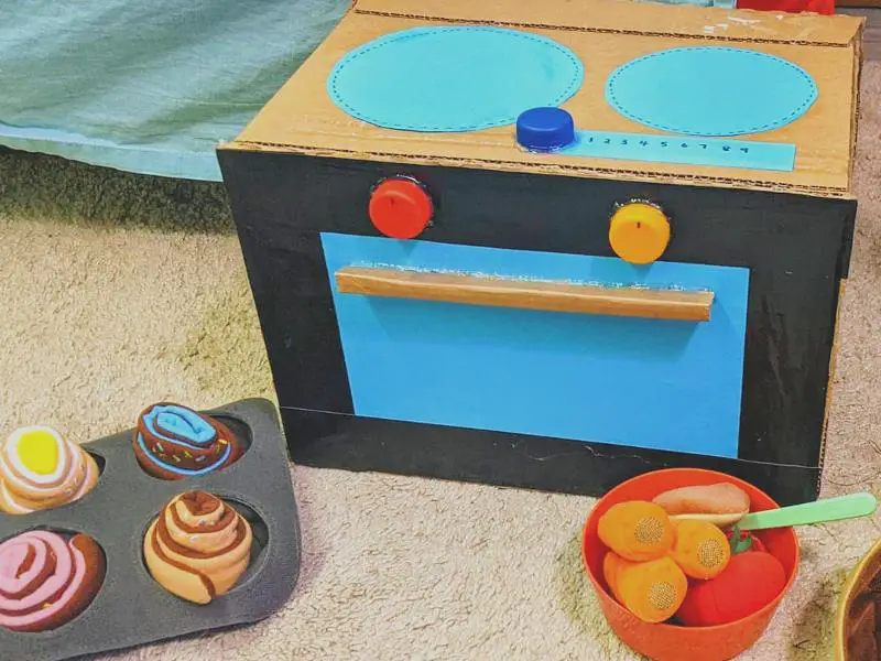 A cardboard oven and cupcakes on a bed helps construct a solar oven.