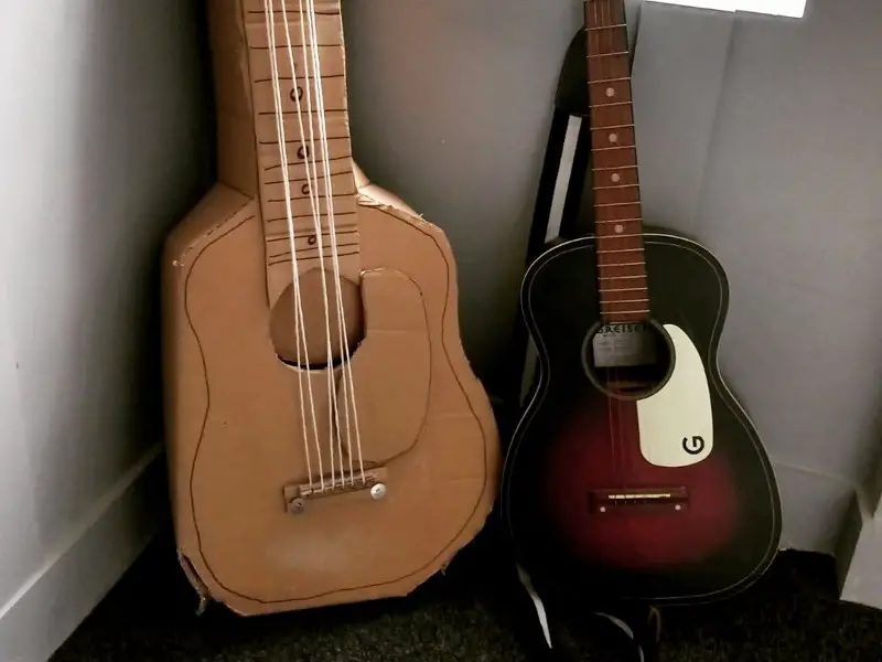 Two acoustic guitars sitting next to each other in a room, transformed into a piano.